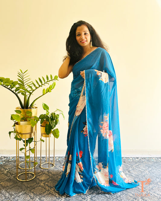 Soft georgette saree with floral prints and elegant pearl lace finish.