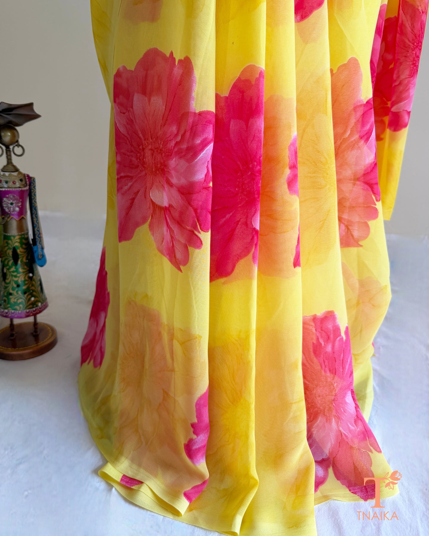 Yellow georgette saree with large pink floral prints