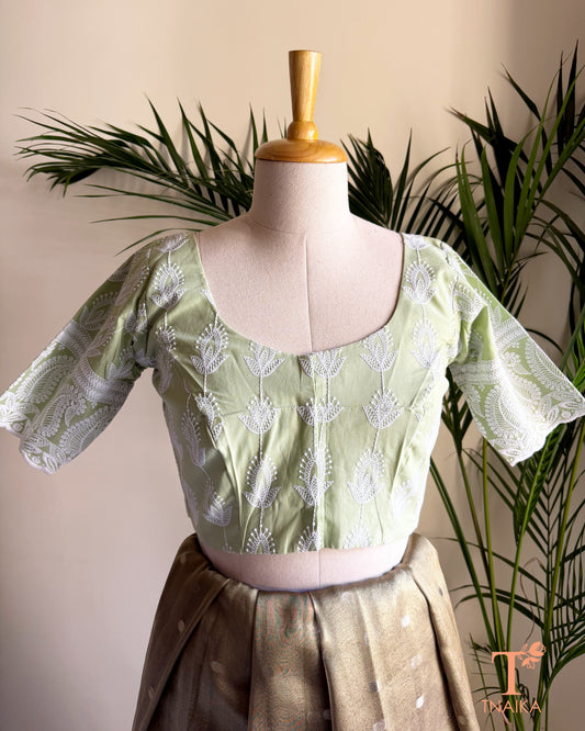 Front view of Tnaika™ pastel pistachio green embroidered cotton blouse with puff sleeves and round neck.
