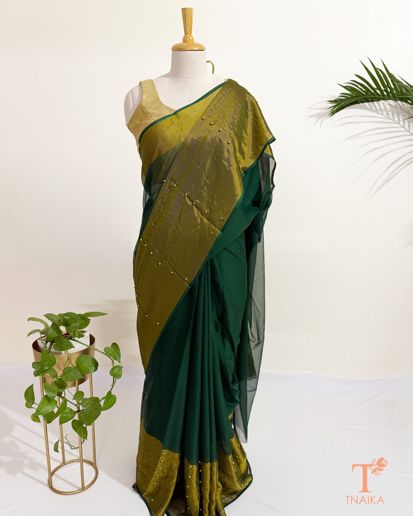 Chiffon saree with antique gold tissue border and pearl pin embellishments.