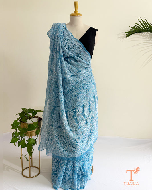 Premium powder blue Lucknowi Chikankari saree with full jaal embroidery and detailed border.