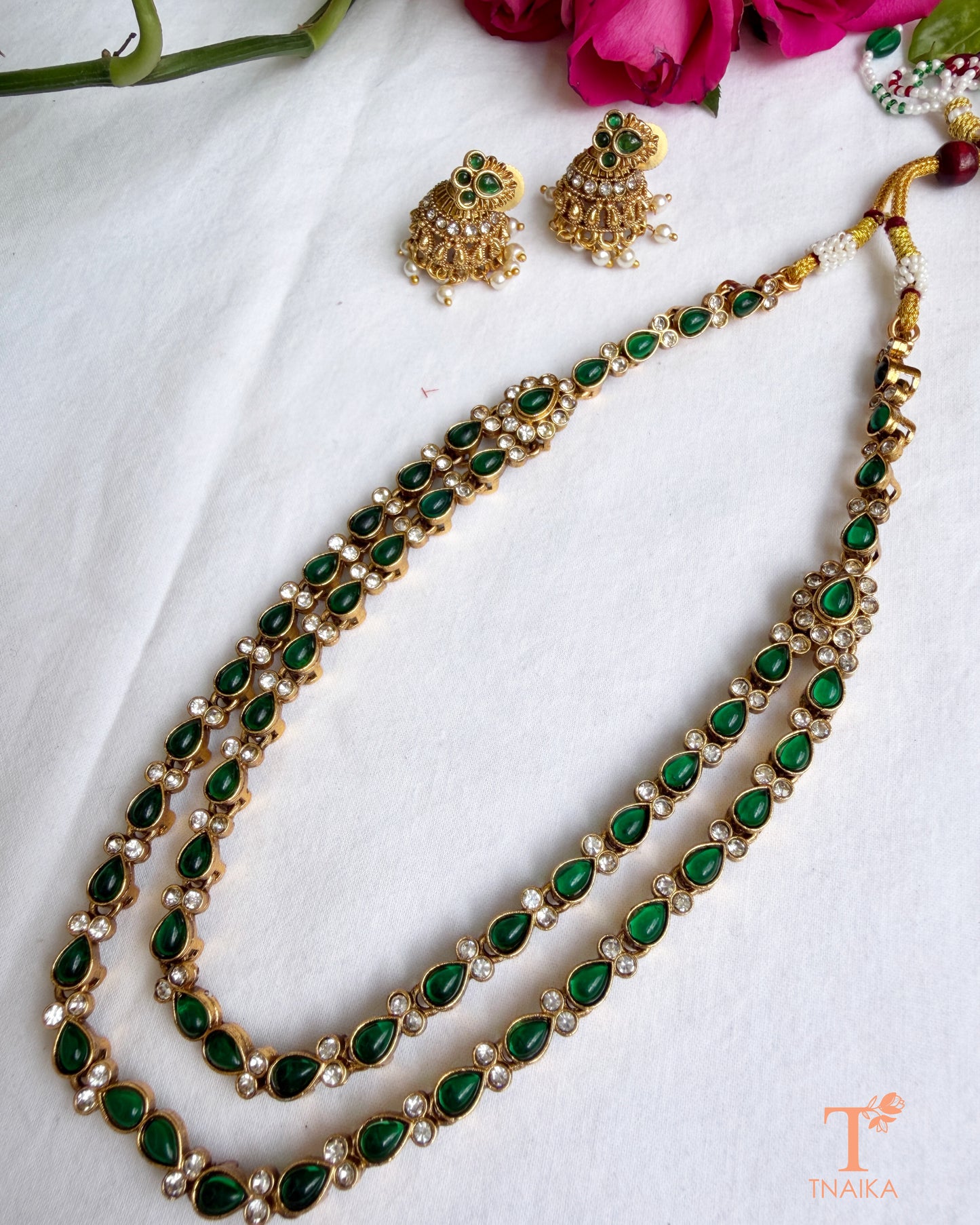 Dual-layer green teardrop stone necklace set with gold polish and traditional jhumki earrings.