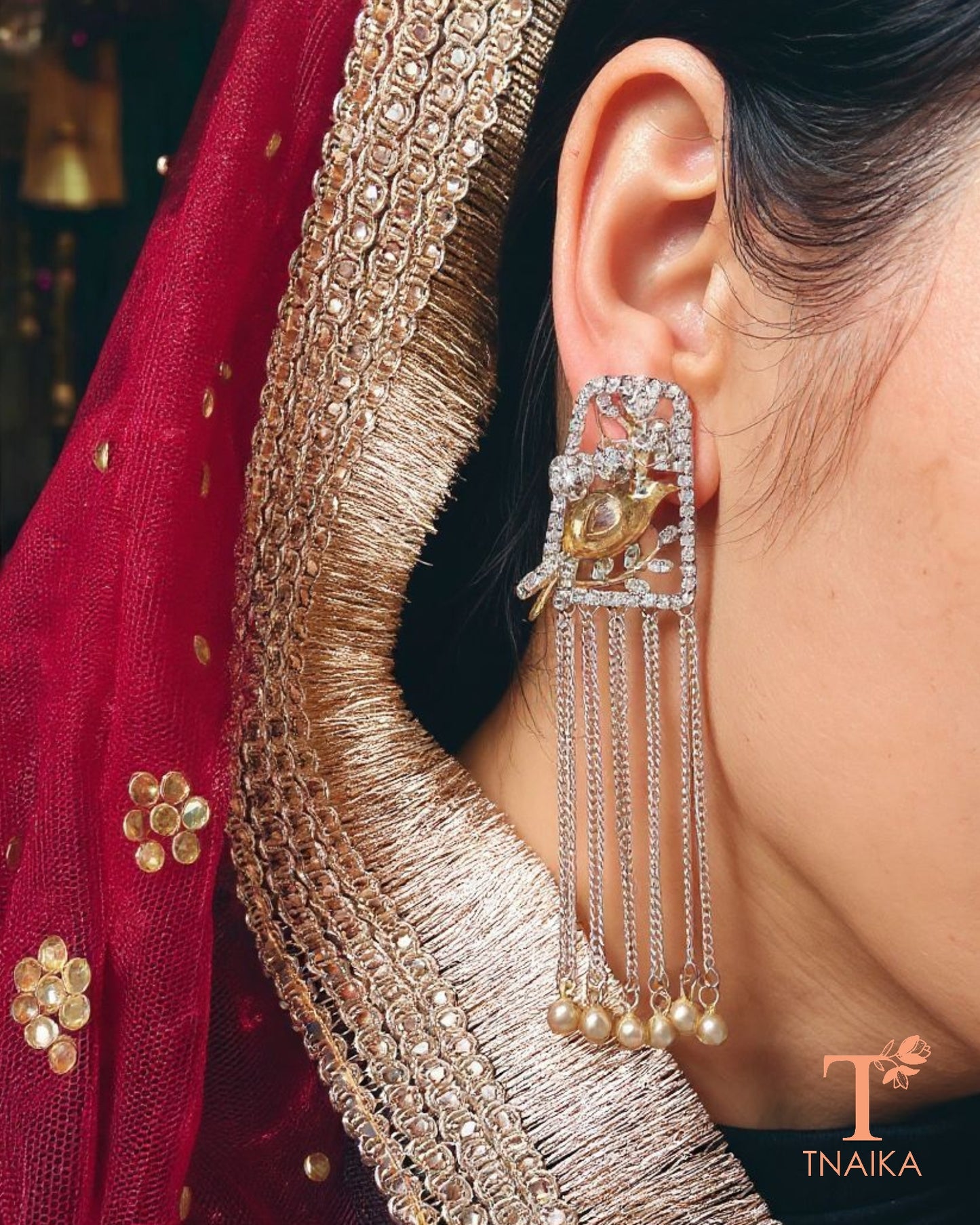 Dual tone silver replica earrings with bird stud and chain hanging design.