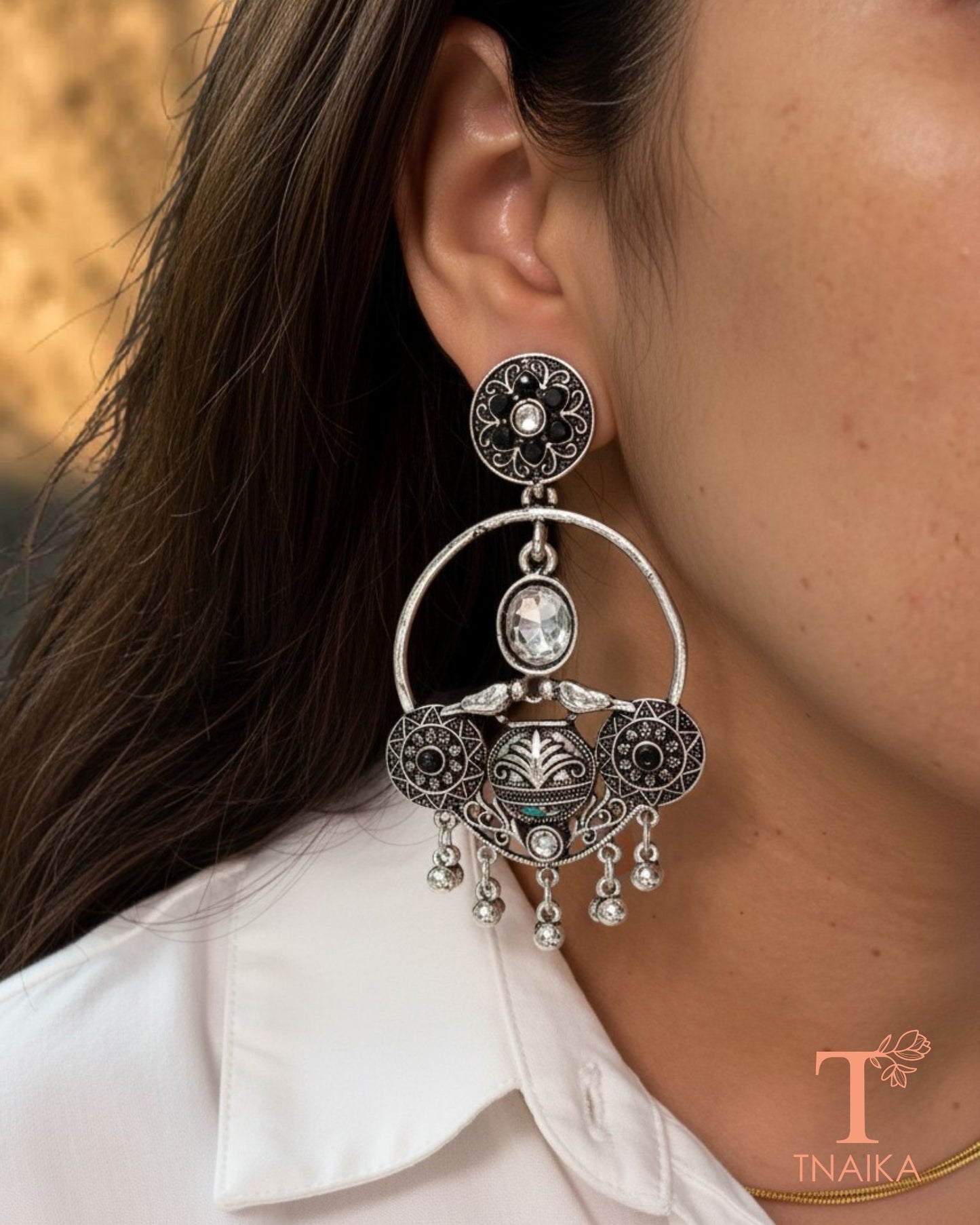 Oxidised silver tone earrings with green stone work and intricate ethnic detailing.