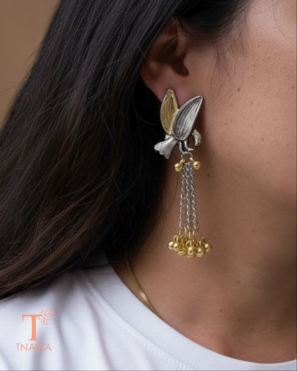 Statement bird motif earrings featuring silver and gold tone detailing.