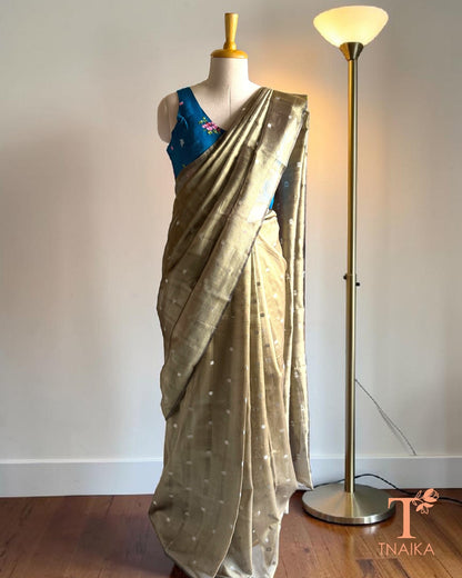 Olive gold tissue silk saree with delicate silver butti motifs and elegant woven border.