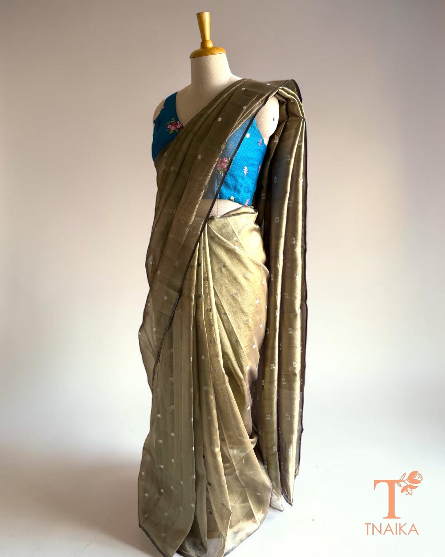 Premium tissue silk saree in olive gold with lightweight shimmer and graceful drape.