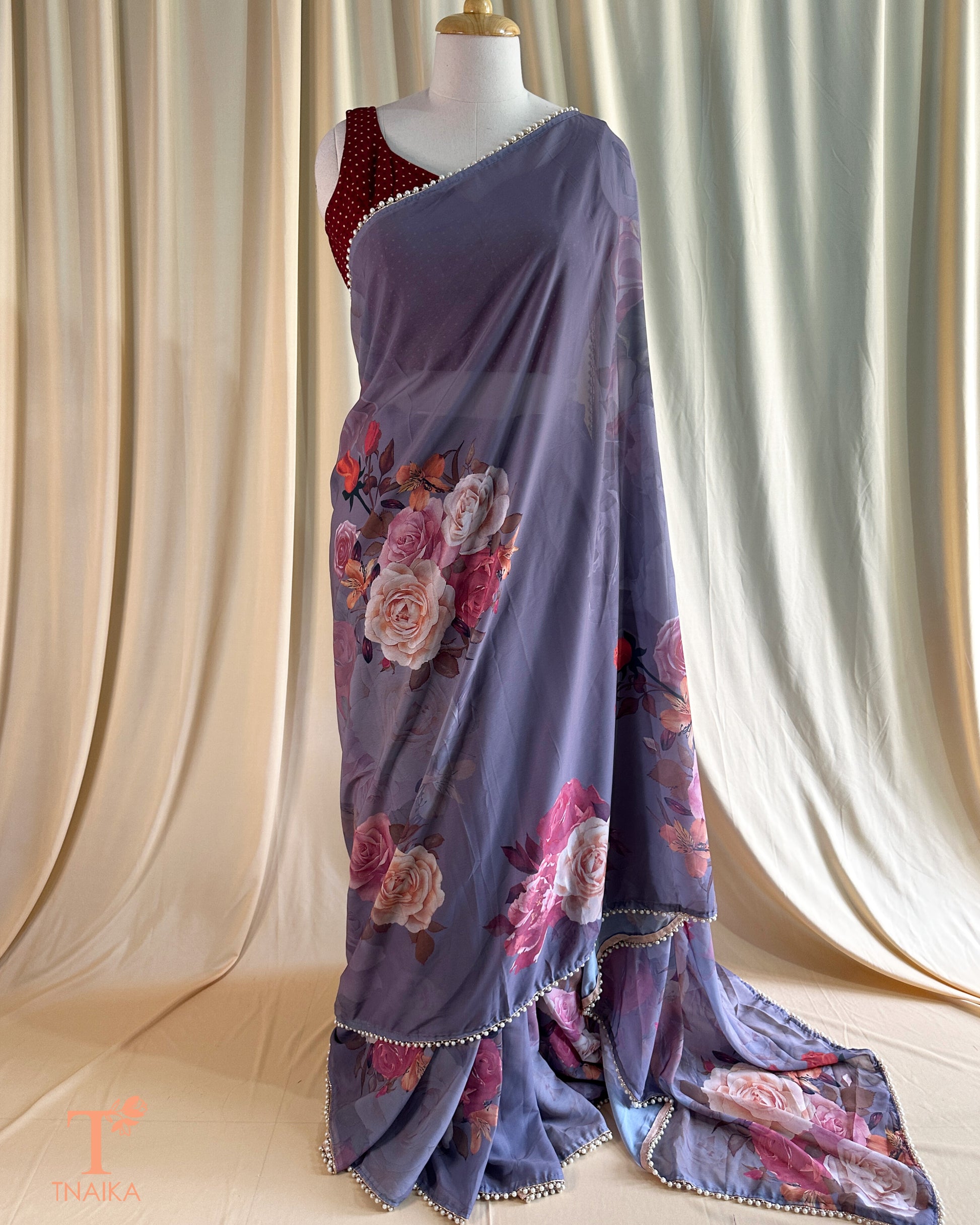 Festive floral georgette saree with pearl lace border, perfect for parties and gatherings.