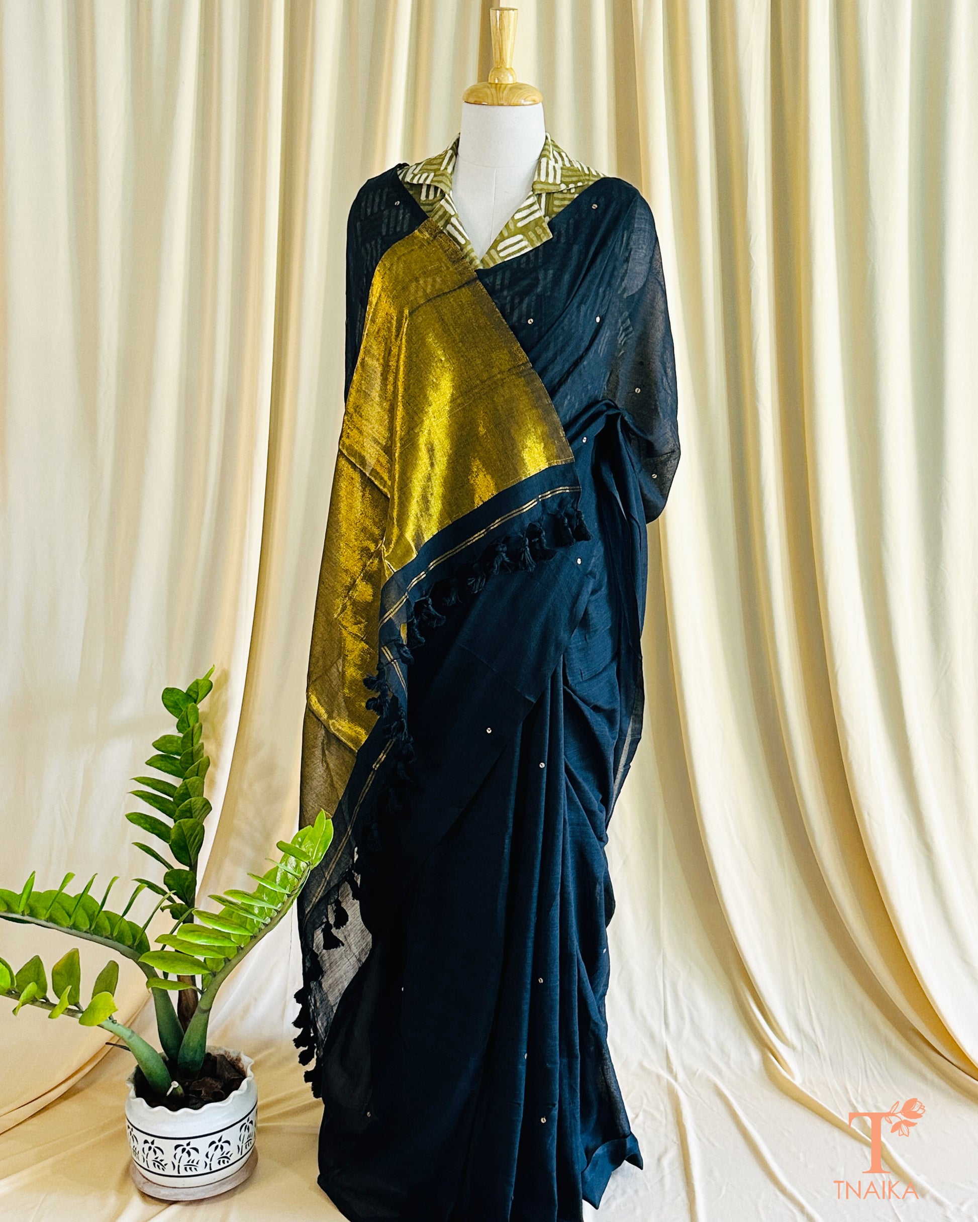 Elegant cotton saree featuring foil detailing and tasselled tissue pallu.