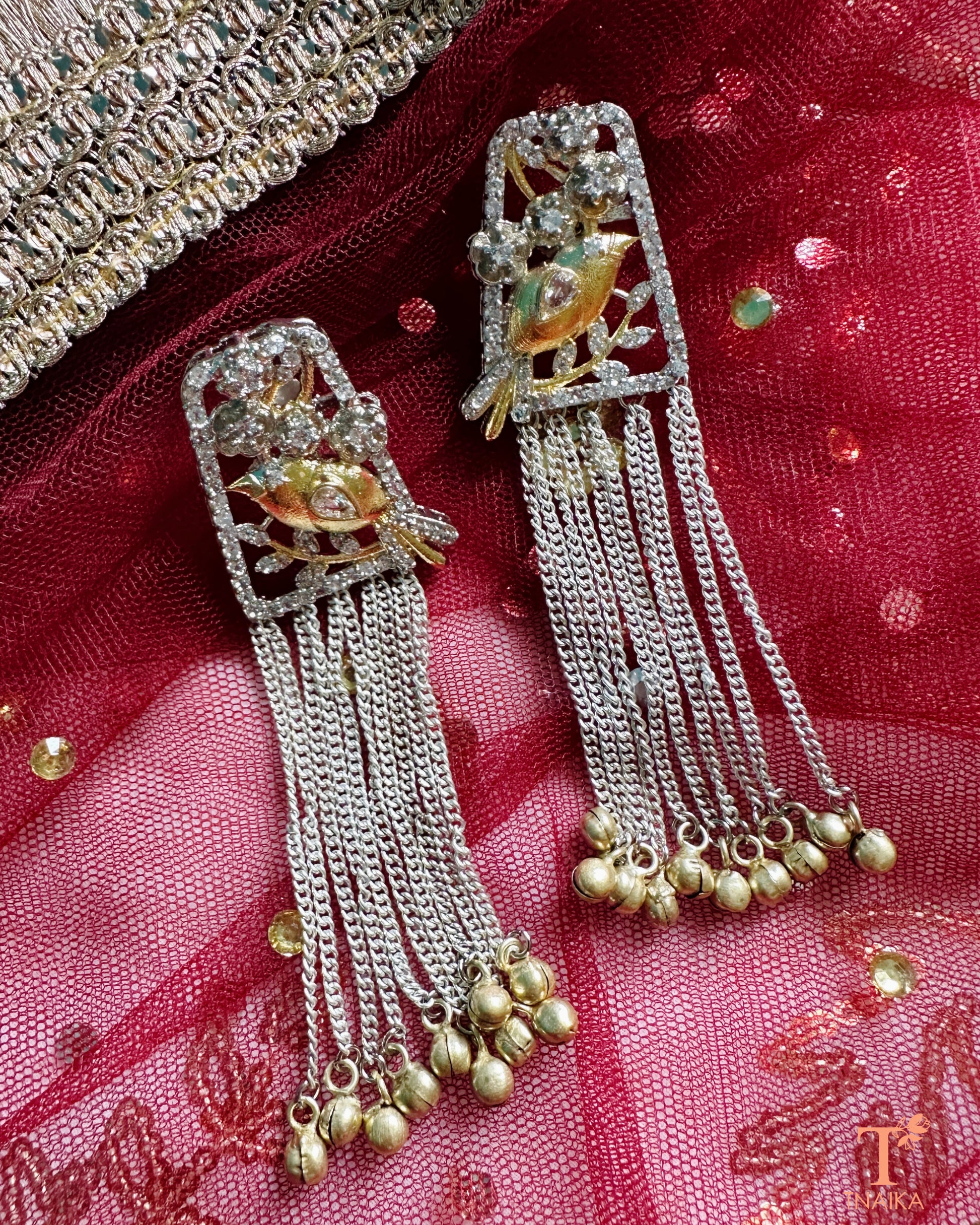 Delicate silver earrings featuring bird motif studs and dual tone finish.