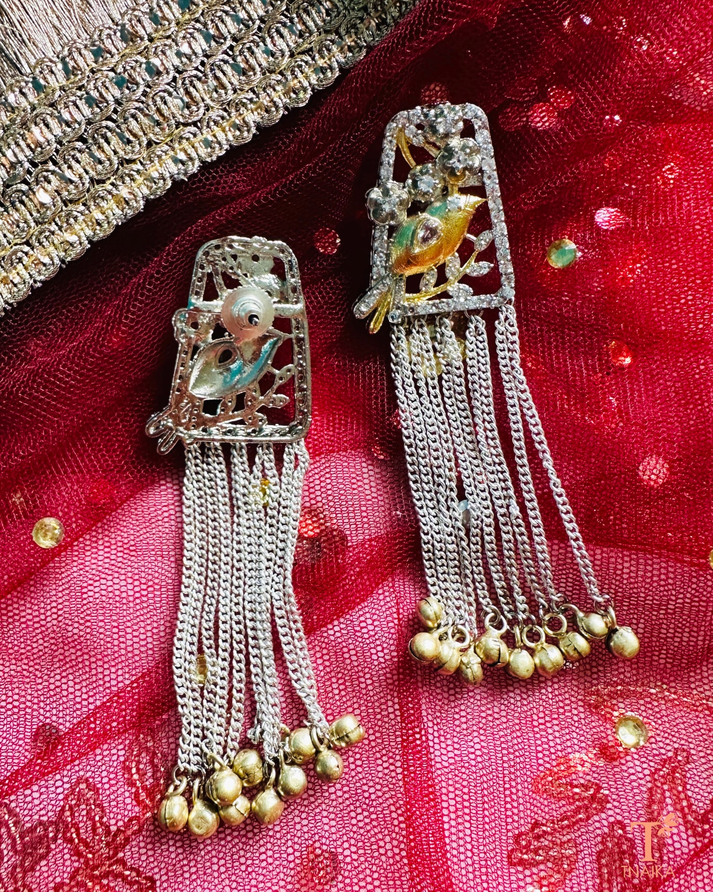 Silver chain drop earrings with handcrafted bird figure detailing.