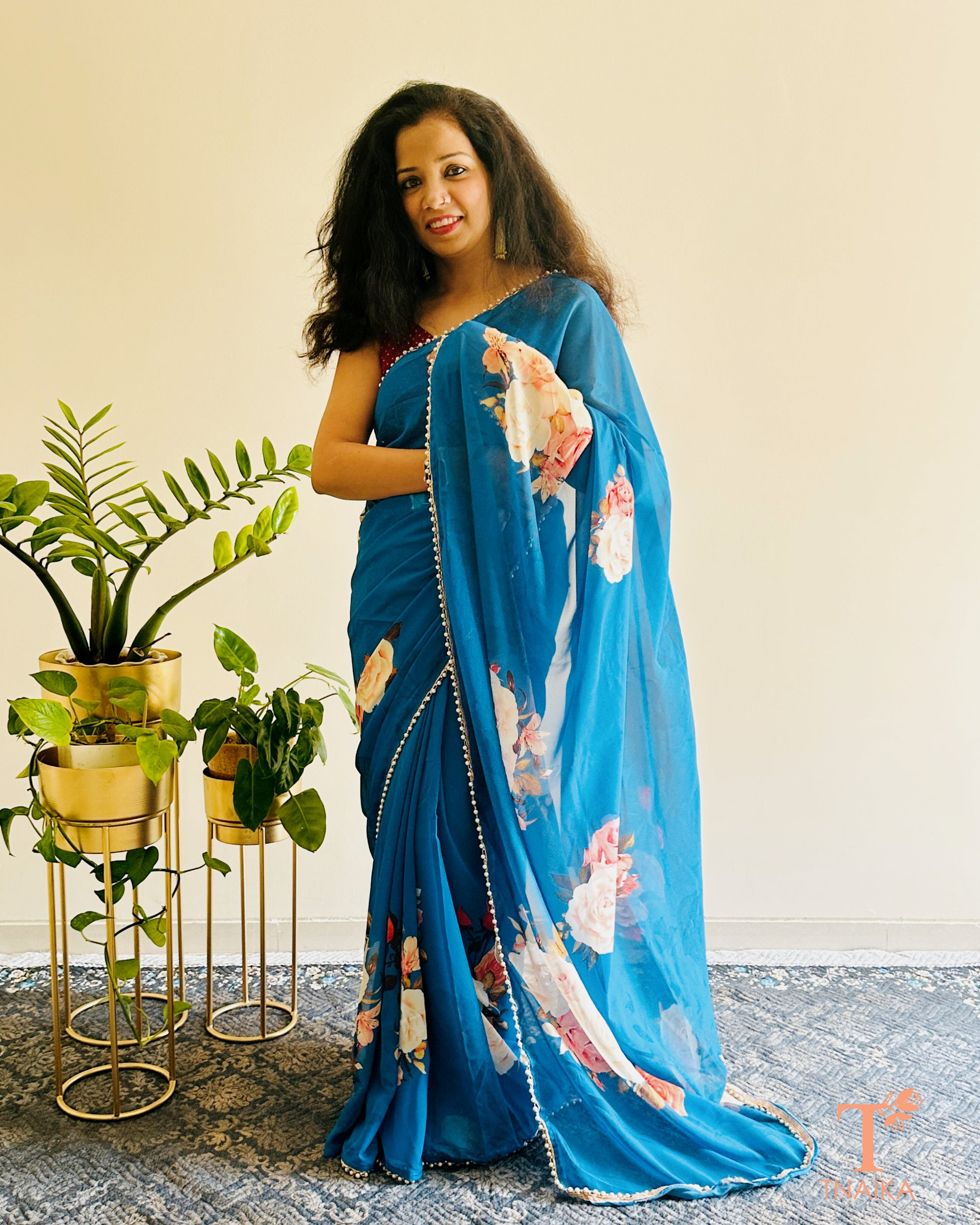 Lightweight floral georgette saree featuring pearl lace detailing for festive wear.