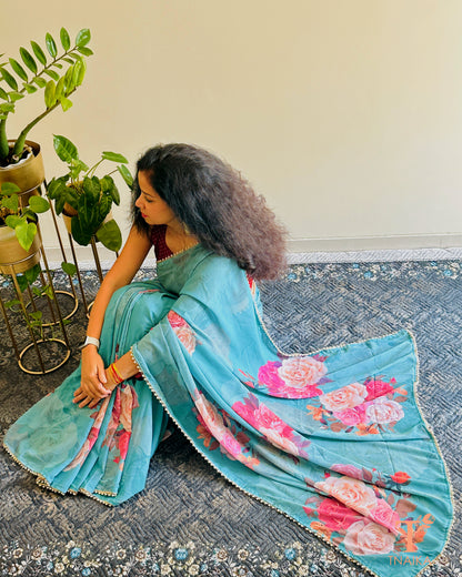 Festive floral georgette saree with pearl lace border, perfect for parties and gatherings.