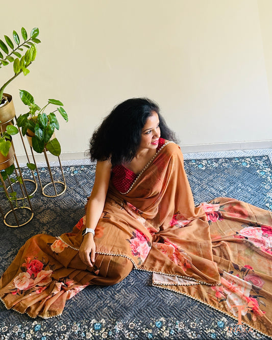 Soft georgette saree with floral prints and elegant pearl lace finish.
