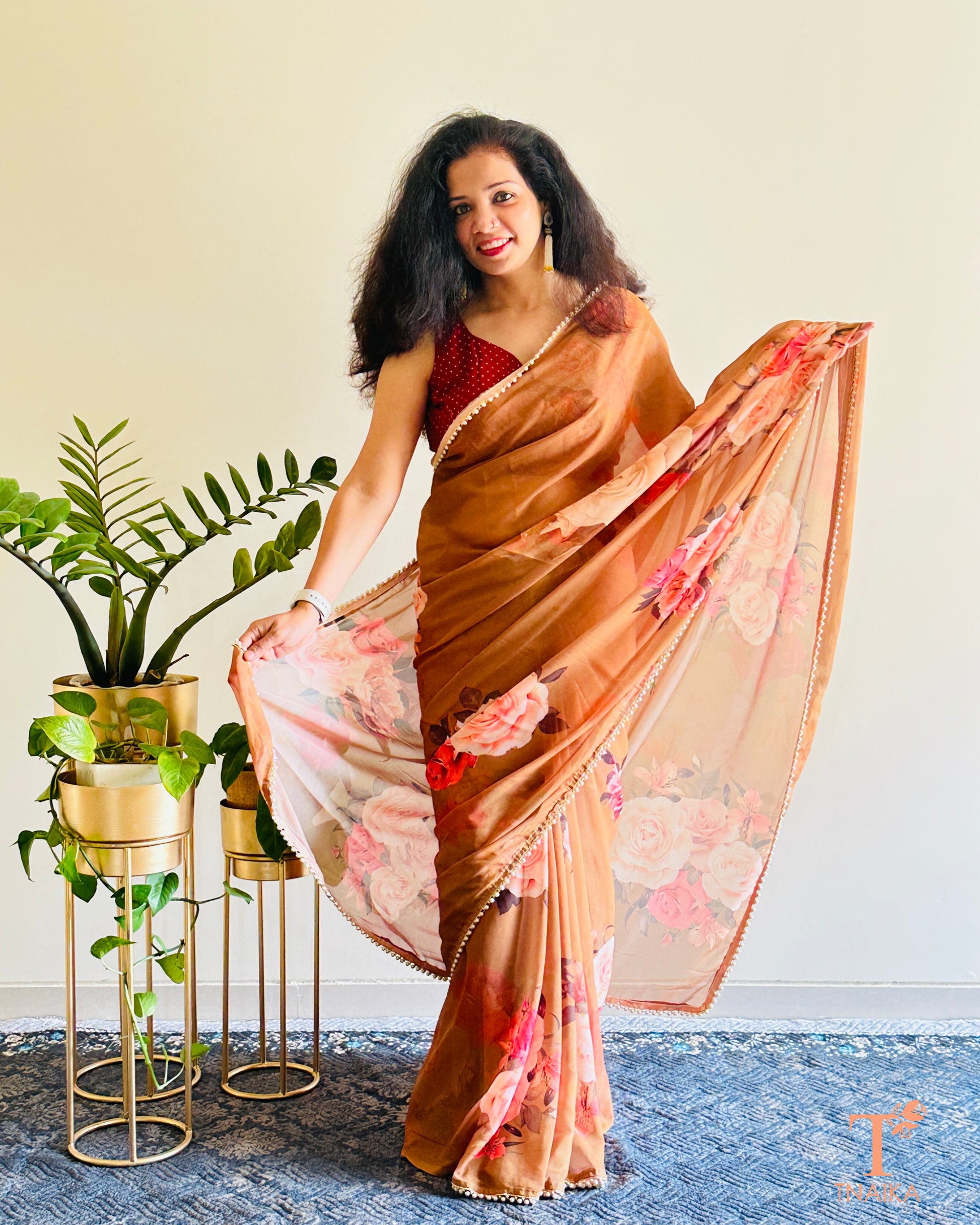 Festive floral georgette saree with pearl lace border, perfect for parties and gatherings.