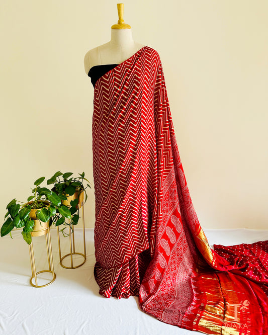 Vibrant leheriya print modal silk saree featuring shimmering tissue pallu with Ajrakh design and matching bandhani print blouse piece.