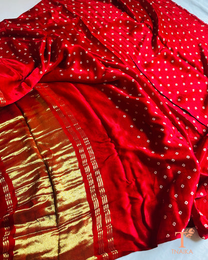 Traditional modal silk leheriya saree with contrast Ajrakh pallu detailing and tissue finish, comes with bandhani print unstitched blouse.