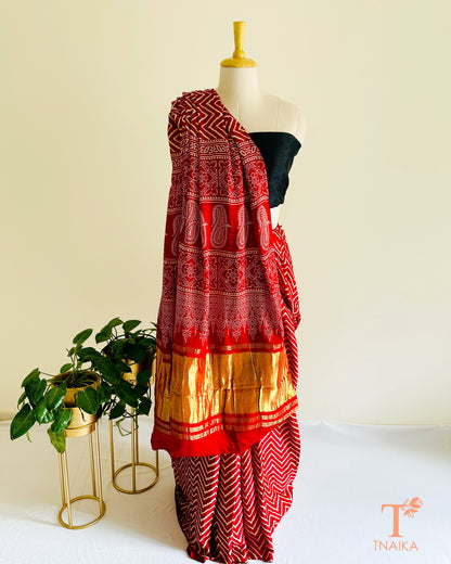 Elegant daytime modal silk leheriya saree with shiny tissue pallu and bold Ajrakh work, with unstitched bandhani printed blouse piece.