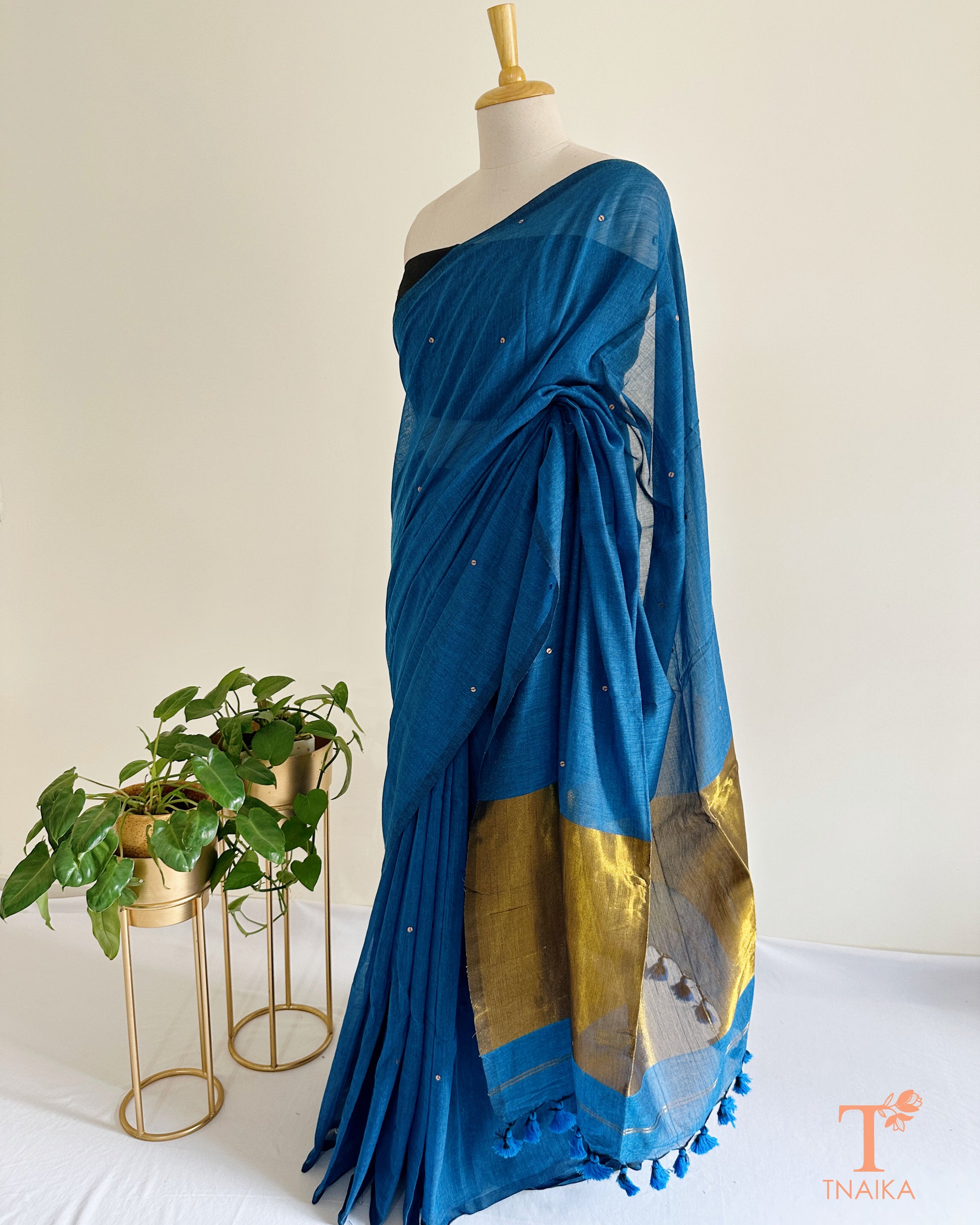 Elegant cotton saree featuring foil detailing and tasselled tissue pallu.
