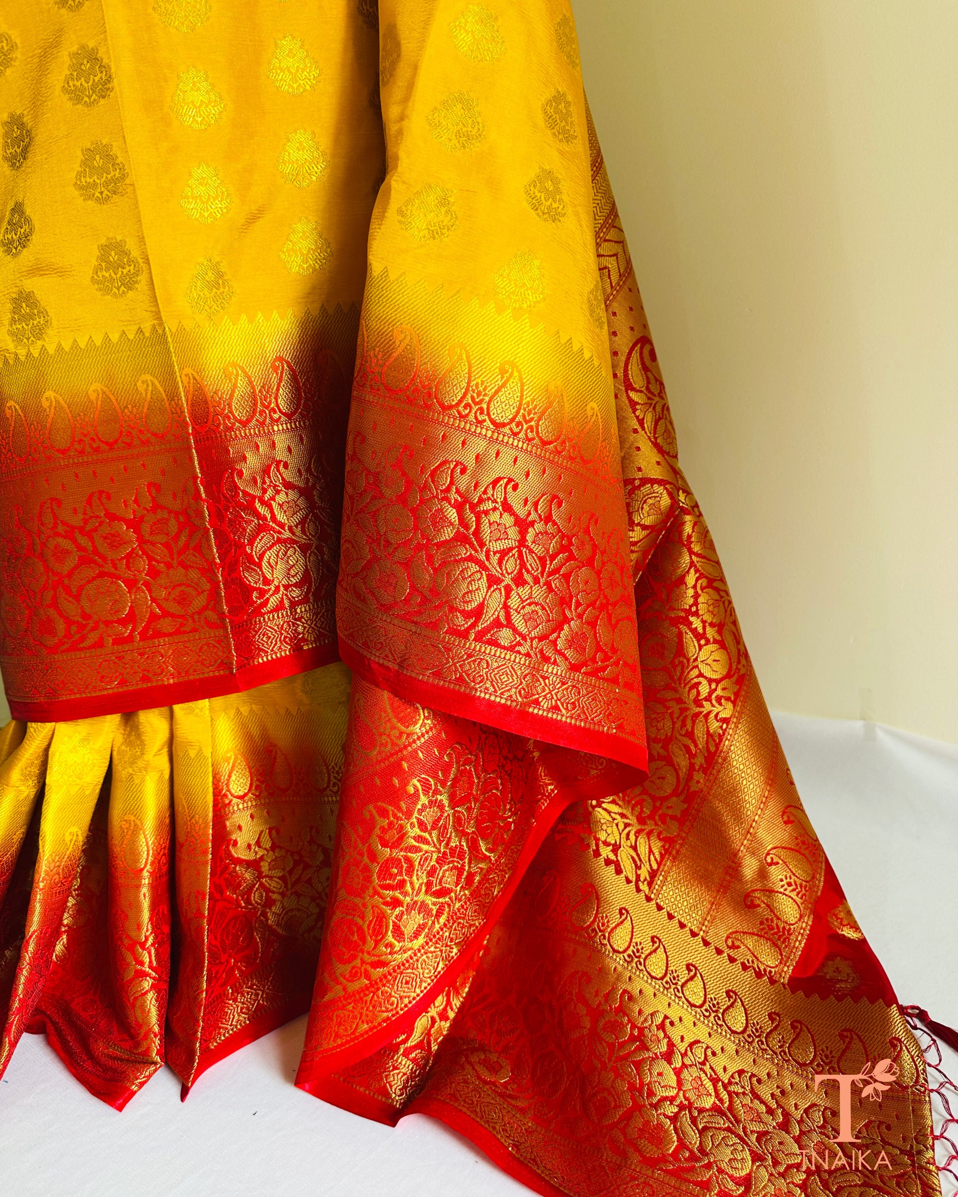 Semi silk saree in bright yellow and red with rich Banarasi inspired look and elegant drape.