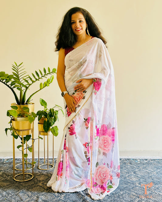 Festive floral georgette saree with pearl lace border, perfect for parties and gatherings.