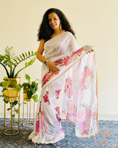Soft georgette saree with floral prints and elegant pearl lace finish.