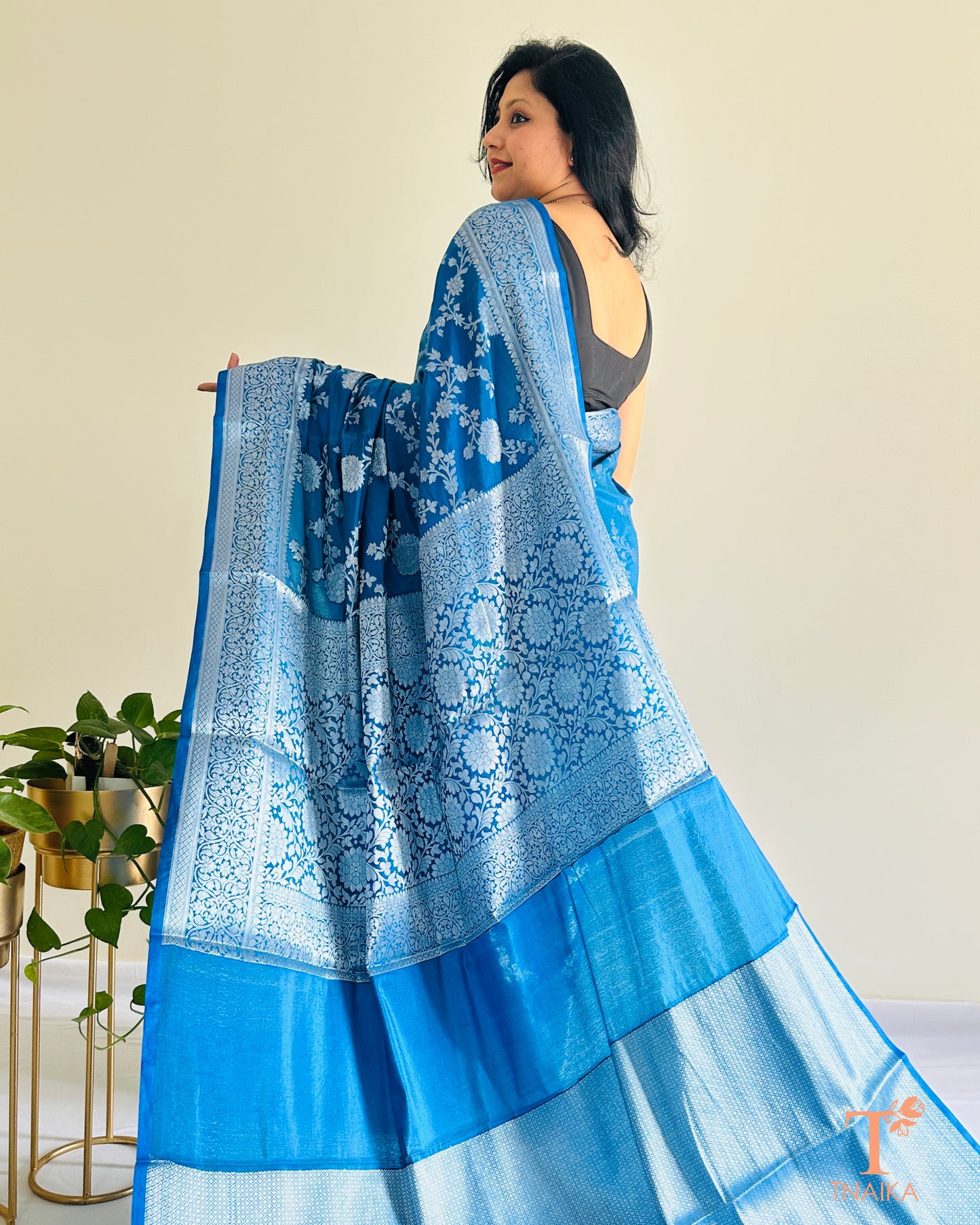 Banarasi silk saree featuring silver zari floral motifs and border