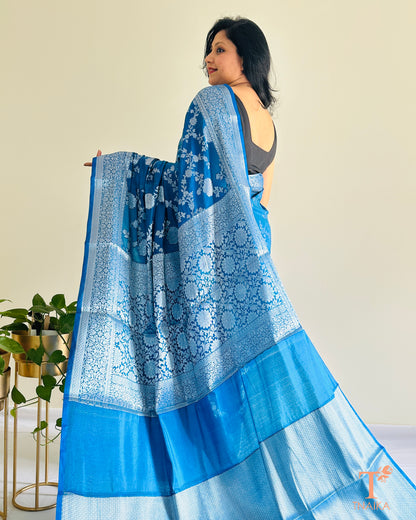 Banarasi silk saree featuring silver zari floral motifs and border