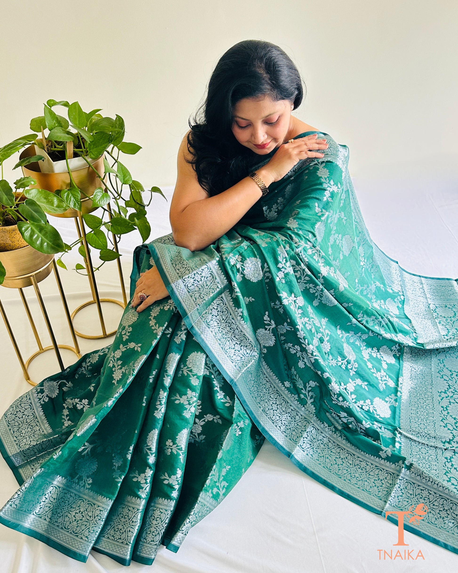 Banarasi silk saree featuring silver zari floral motifs and border