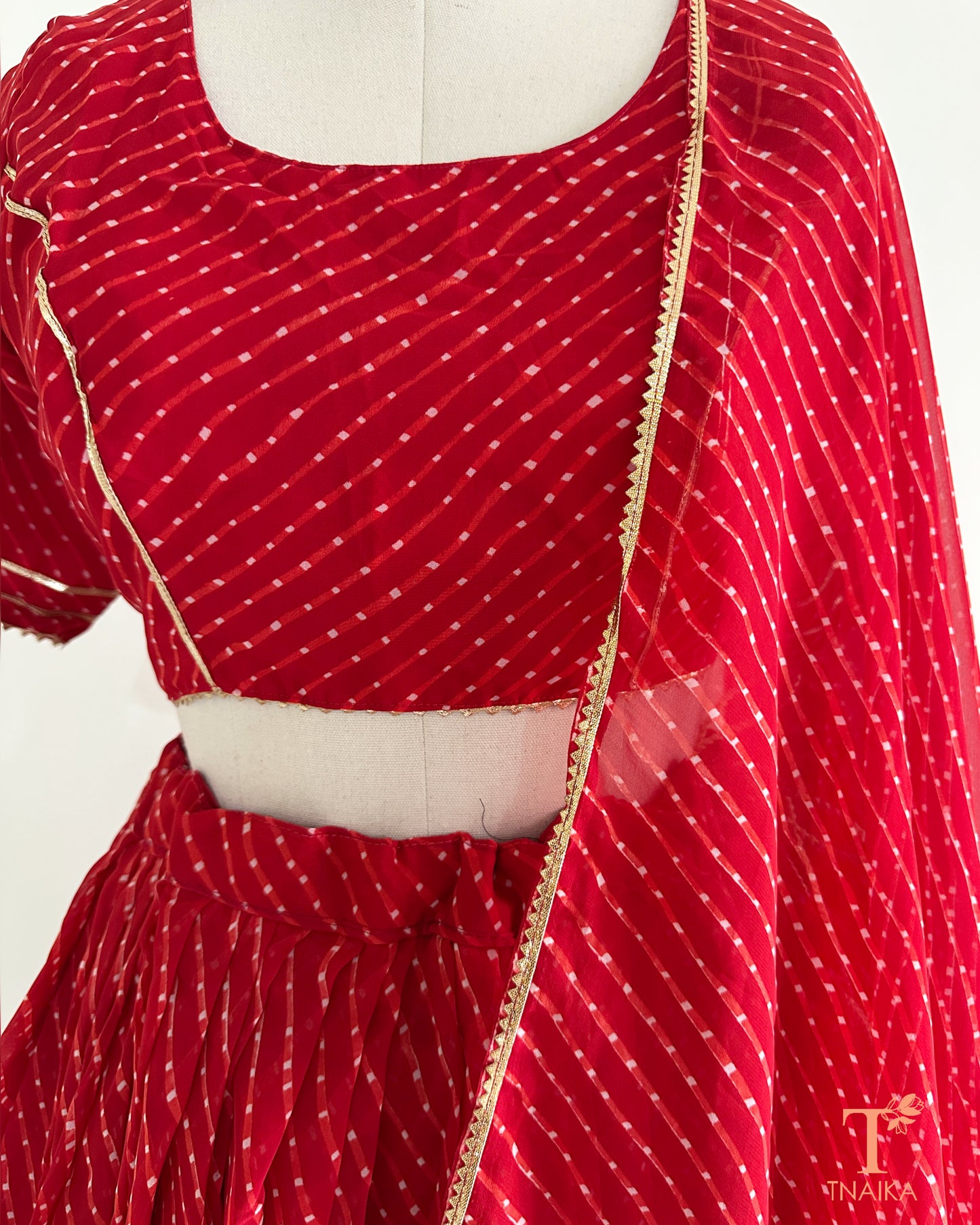 Vibrant Leheriya georgette lehenga featuring lace detailing, ideal for weddings and festive occasions