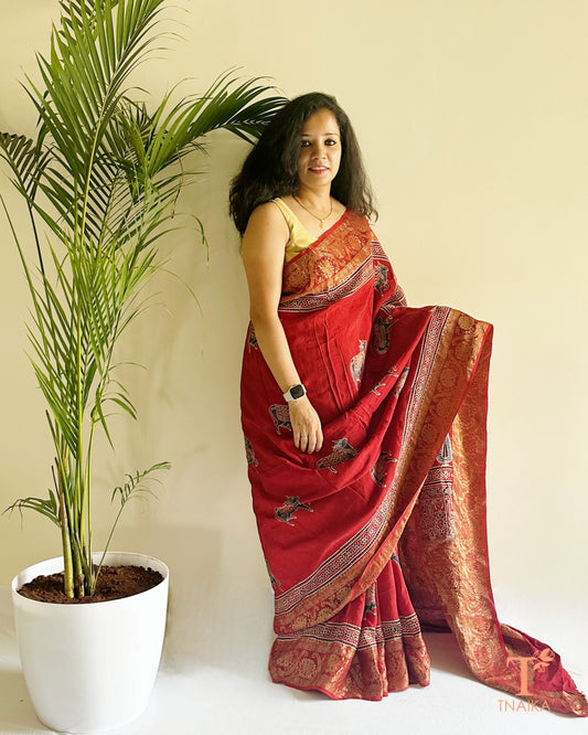 Traditional red silk saree with woven motifs and detailed pallu