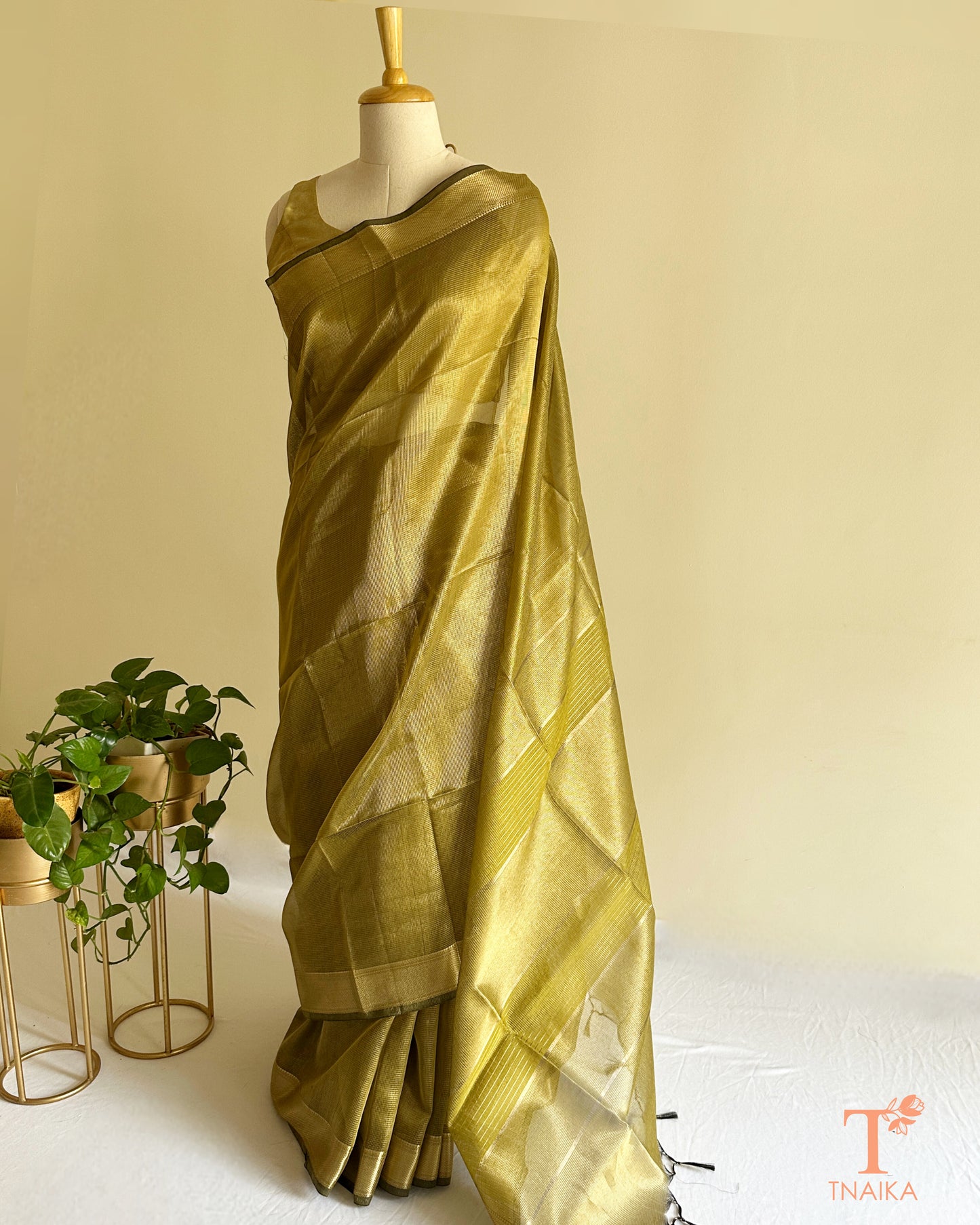 Olive gold tissue silk saree with zari border and tassel pallu draped on mannequin by Tnaika™