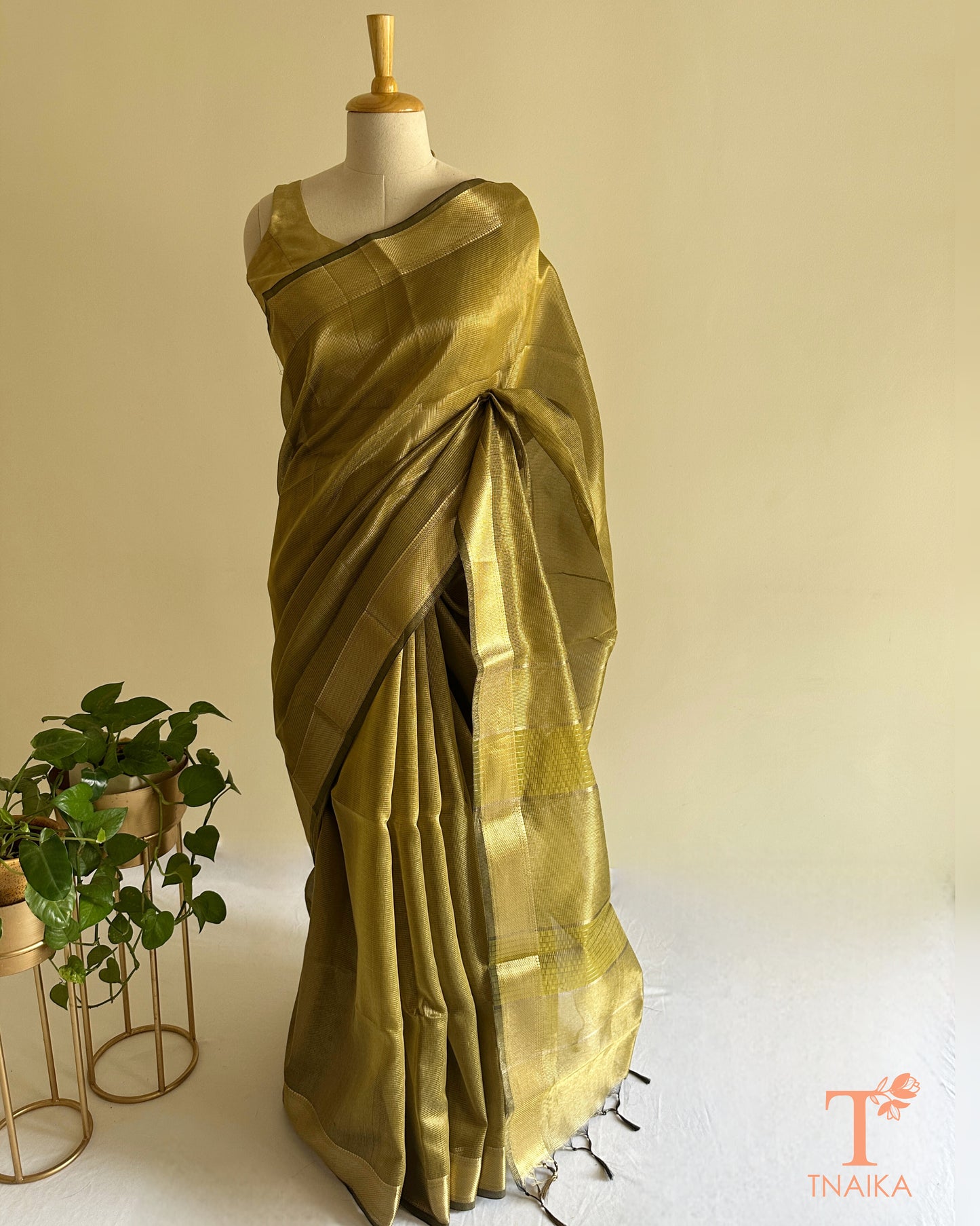 Close-up of olive green tissue silk saree featuring fine checks weave, zari border, and striped pallu detailing