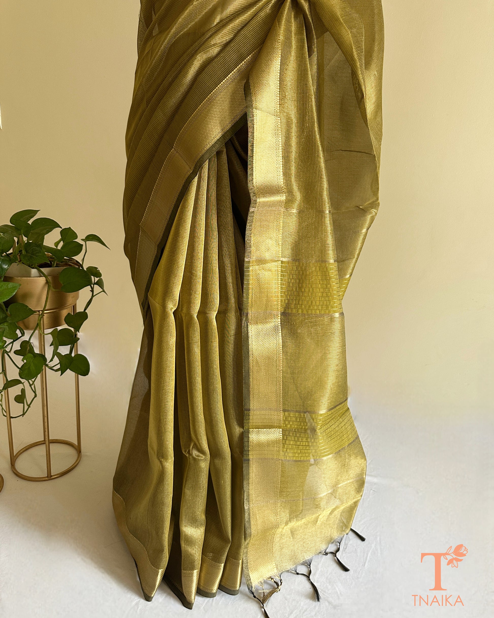 Soft shimmer olive tissue silk saree with subtle micro checks and traditional zari accents for festive wear