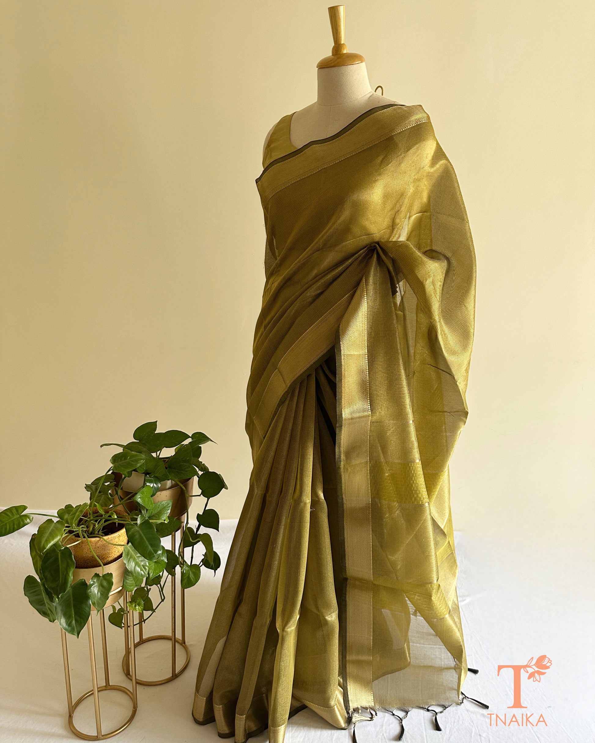 Elegant olive gold tissue silk saree with translucent drape, woven borders, and tassel edge detailing