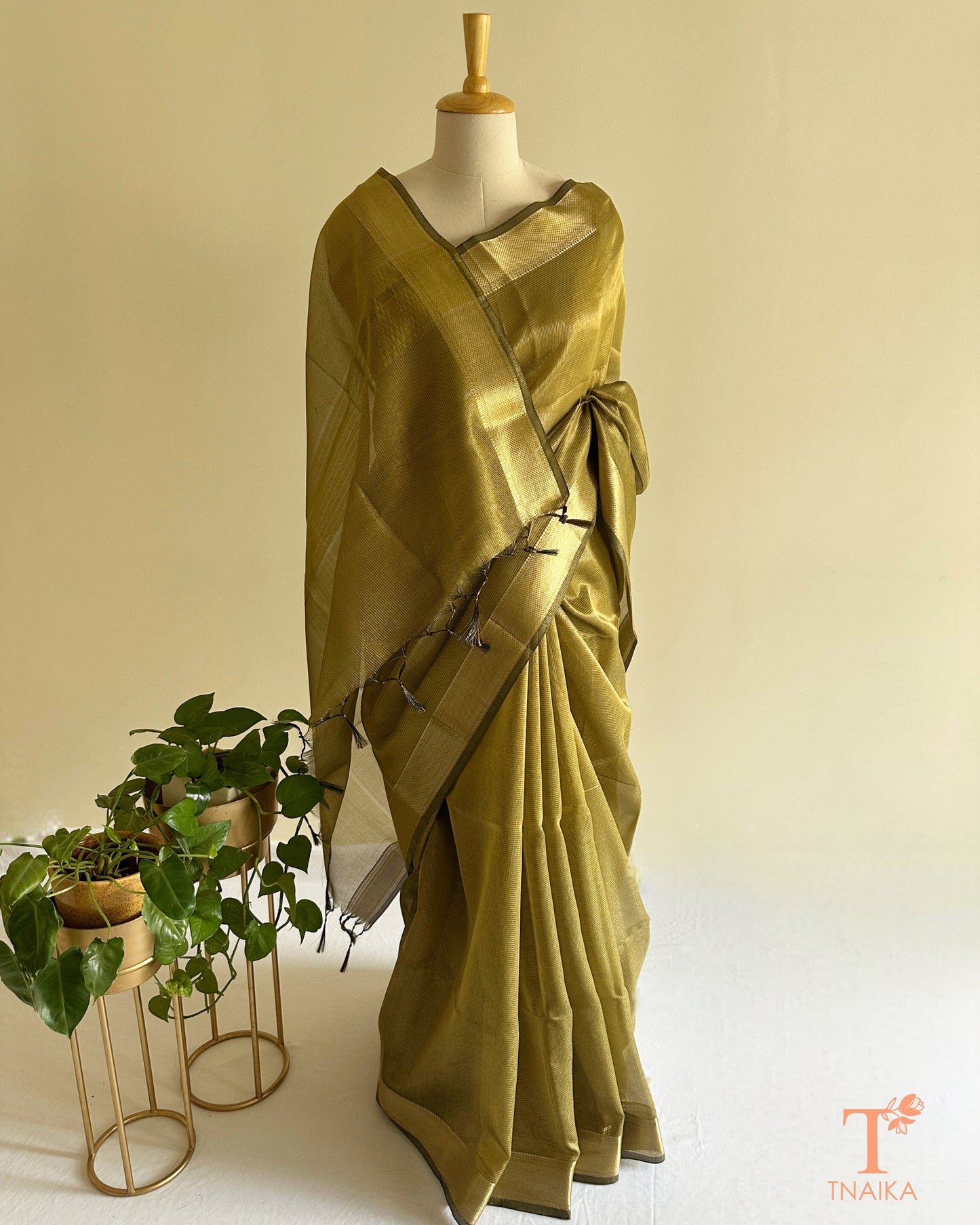 Soft shimmer olive tissue silk saree with subtle micro checks and traditional zari accents for festive wear