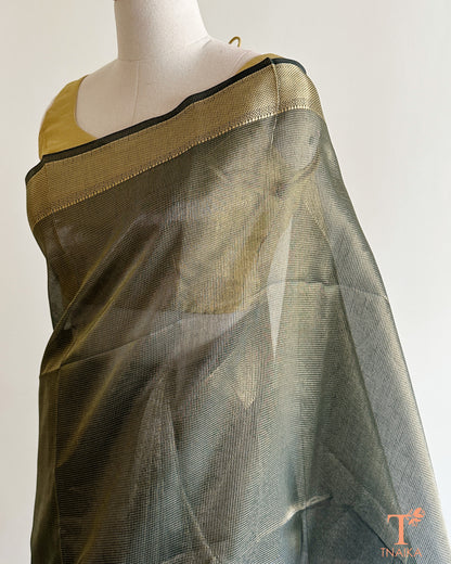 Close-up of muted olive green tissue silk saree featuring fine micro checks, antique gold zari weave, and striped pallu design