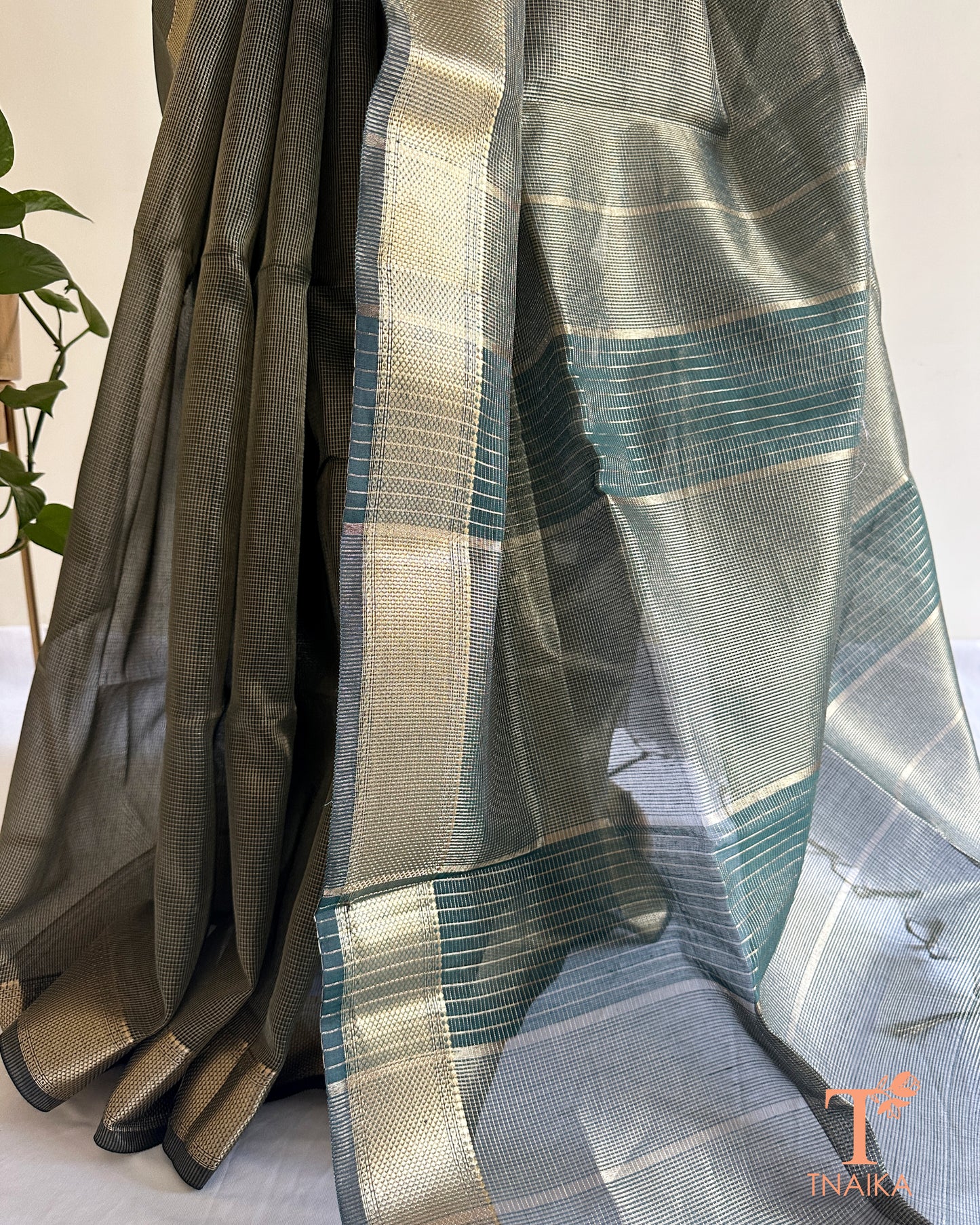 Lightweight muted green tissue silk saree with soft shimmer and traditional woven zari detailing