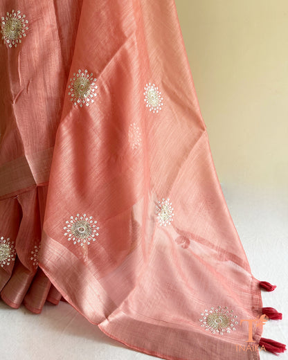 Close-up of pink cotton saree showcasing intricate butti embroidery and graceful woven border