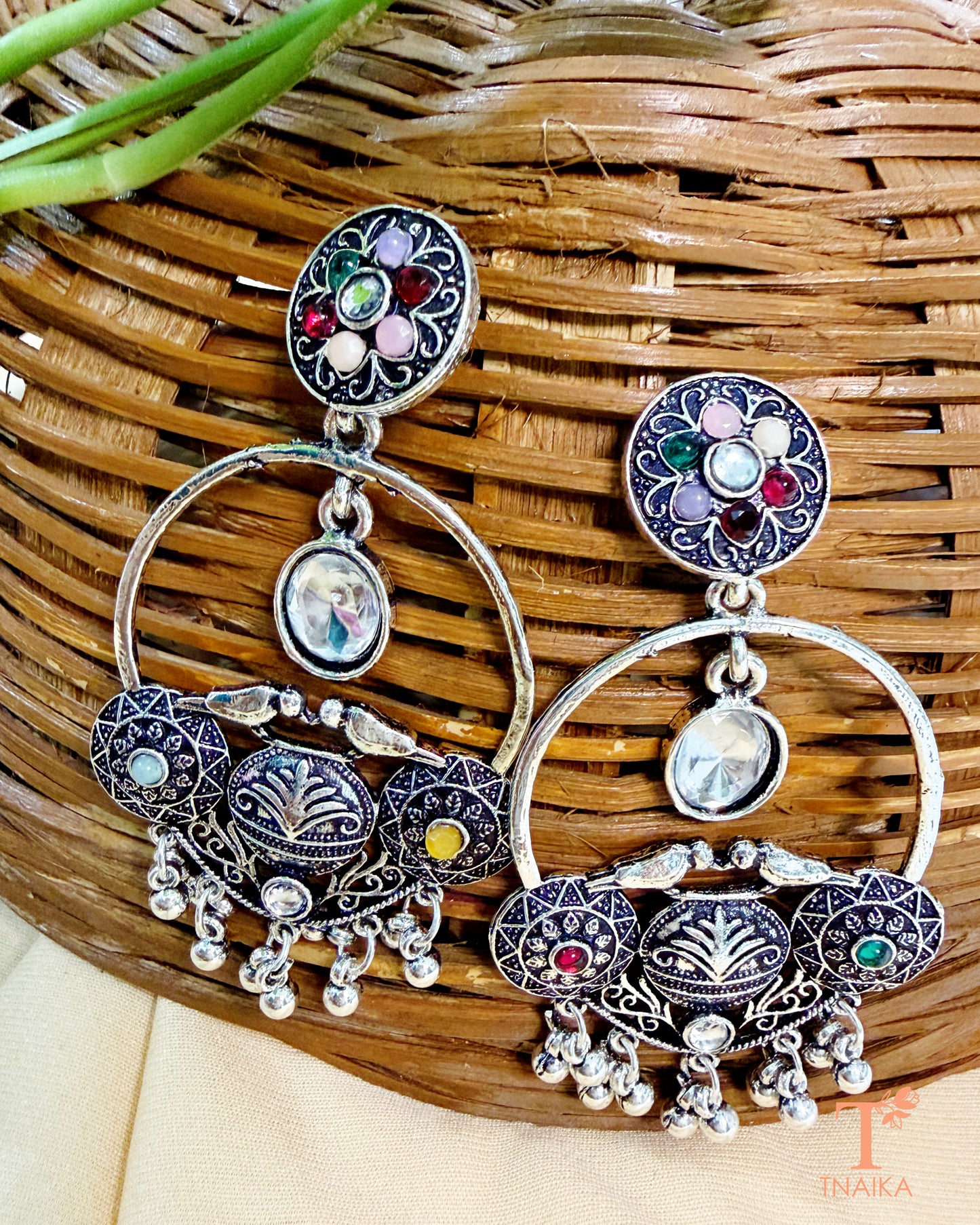 Traditional oxidised statement earrings featuring colorful stones and dangling accents.