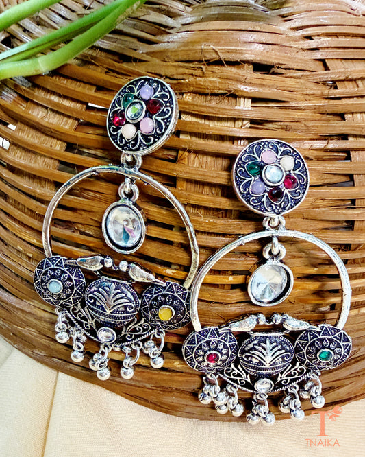 Traditional oxidised statement earrings featuring colorful stones and dangling accents.