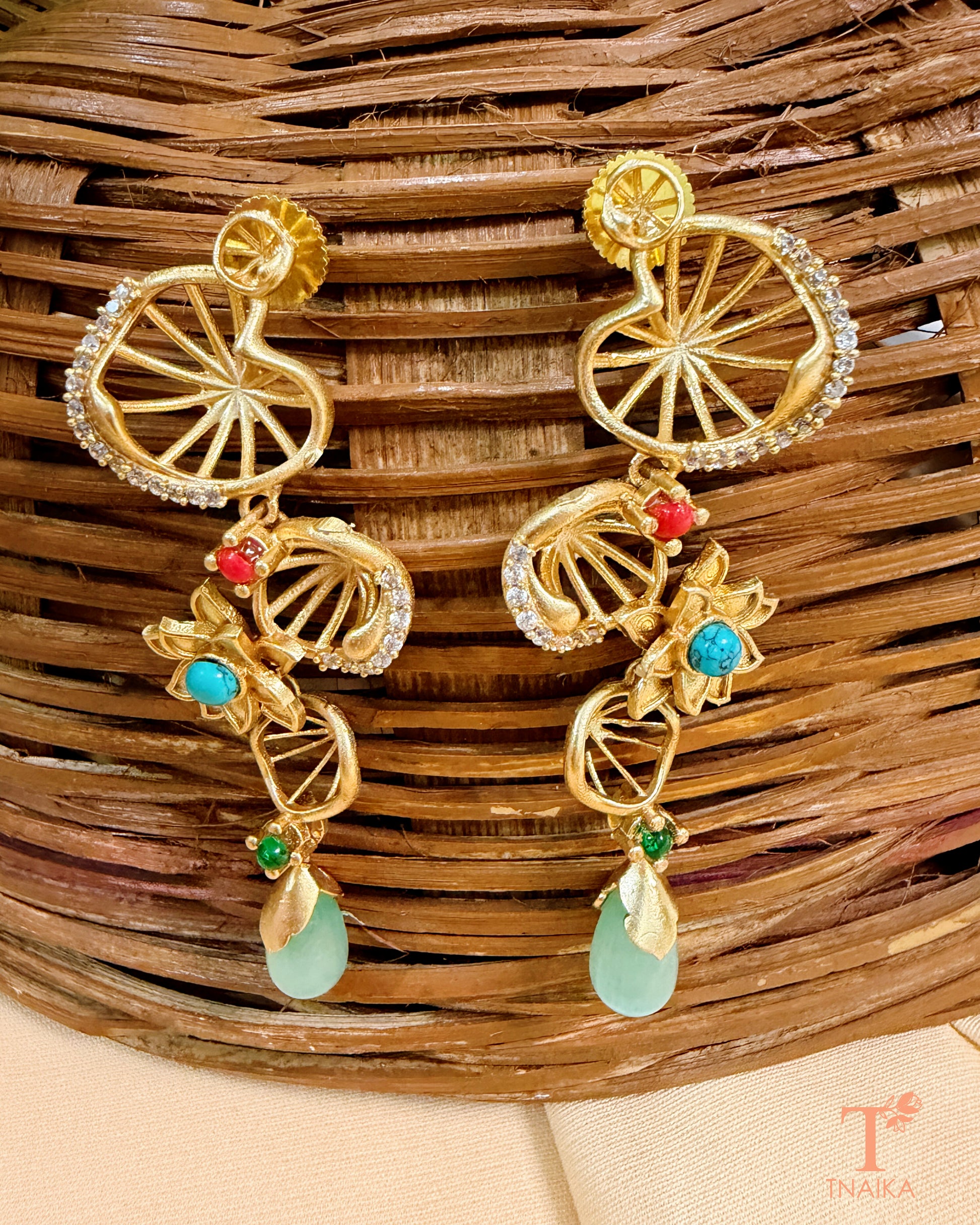 Gold finish brass earrings with AD stone work, floral motifs and elegant drop detailing.