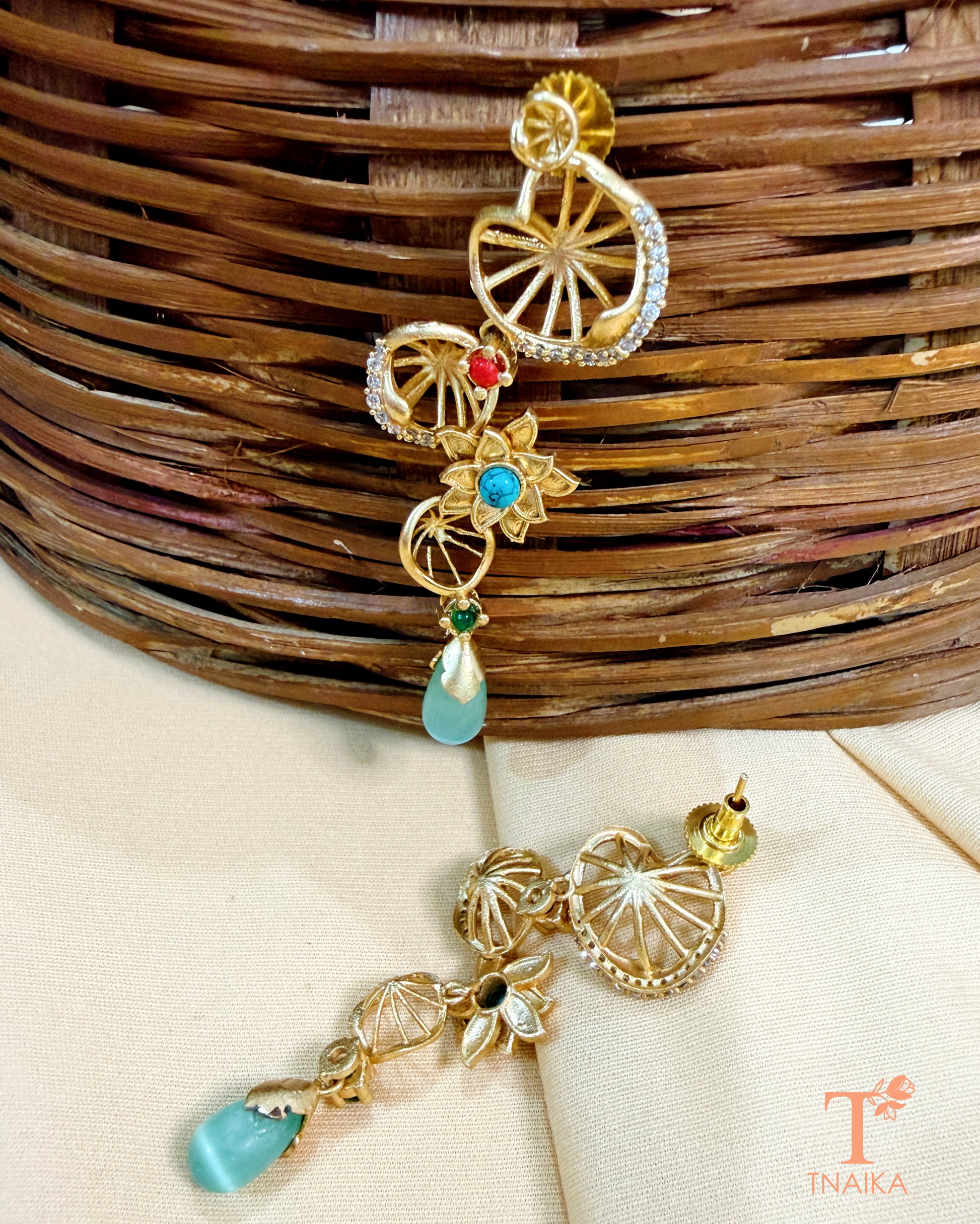 Designer gold finish brass earrings with floral details and hanging drops.