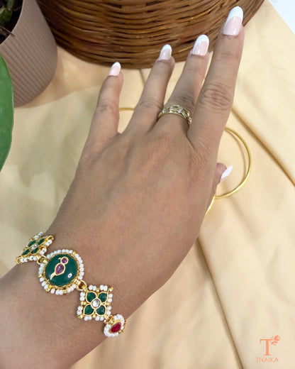 Adjustable gold finish brass bracelet featuring green enamel and handcrafted kundan detailing.