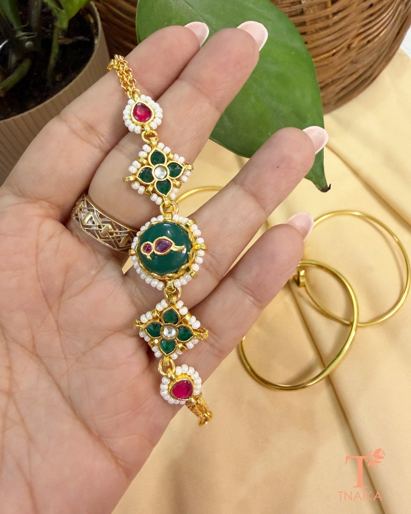 Traditional adjustable brass bracelet with green enamel, kundan stones, and polished gold finish.