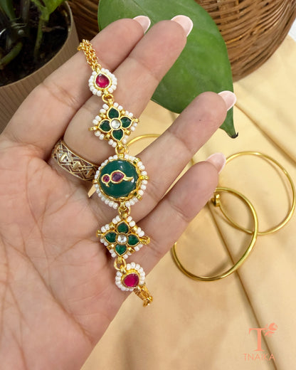 Traditional adjustable brass bracelet with green enamel, kundan stones, and polished gold finish.