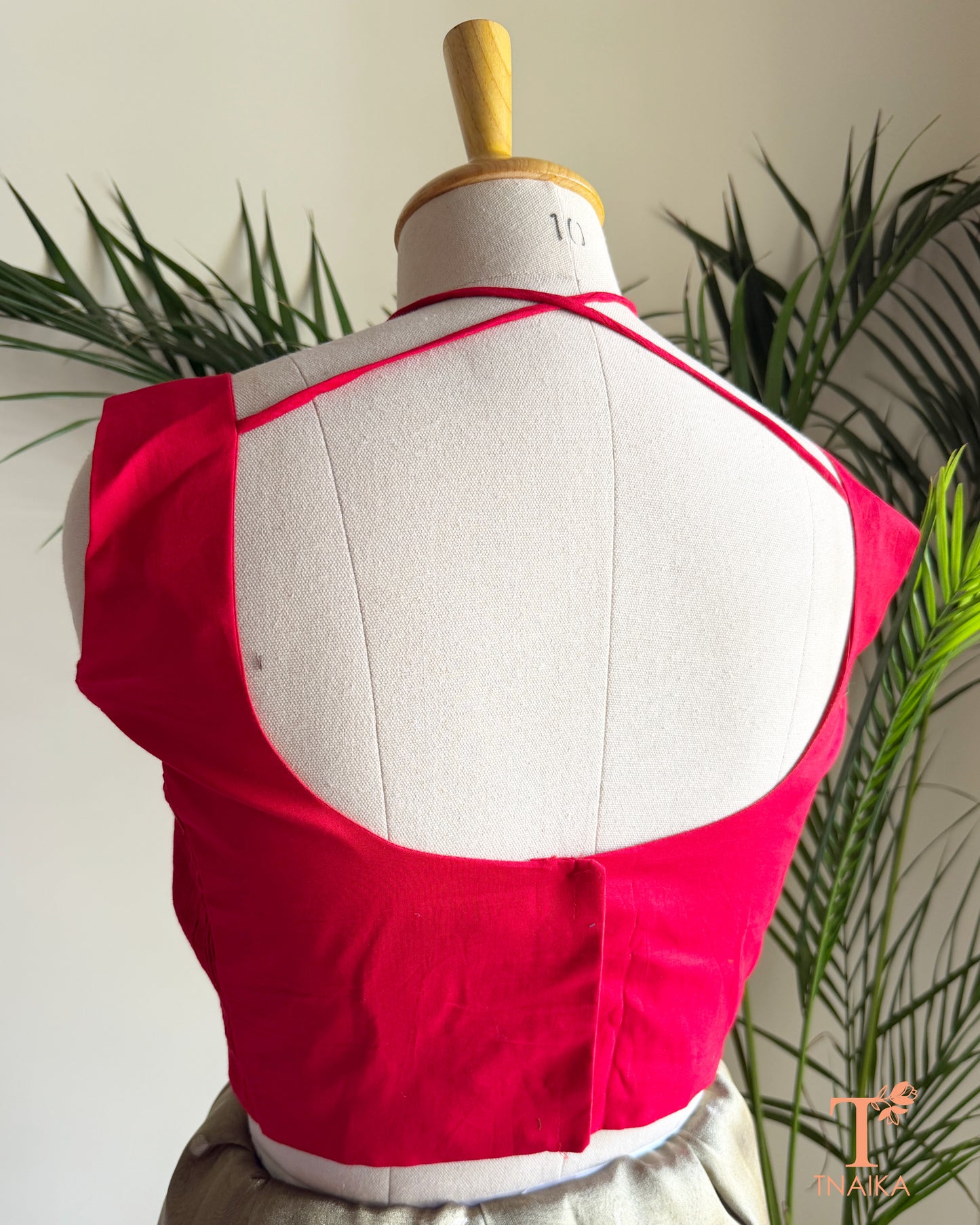 Designer cotton silk blouse with a stylish deep back neck and adjustable tie-up closure for a graceful saree look.