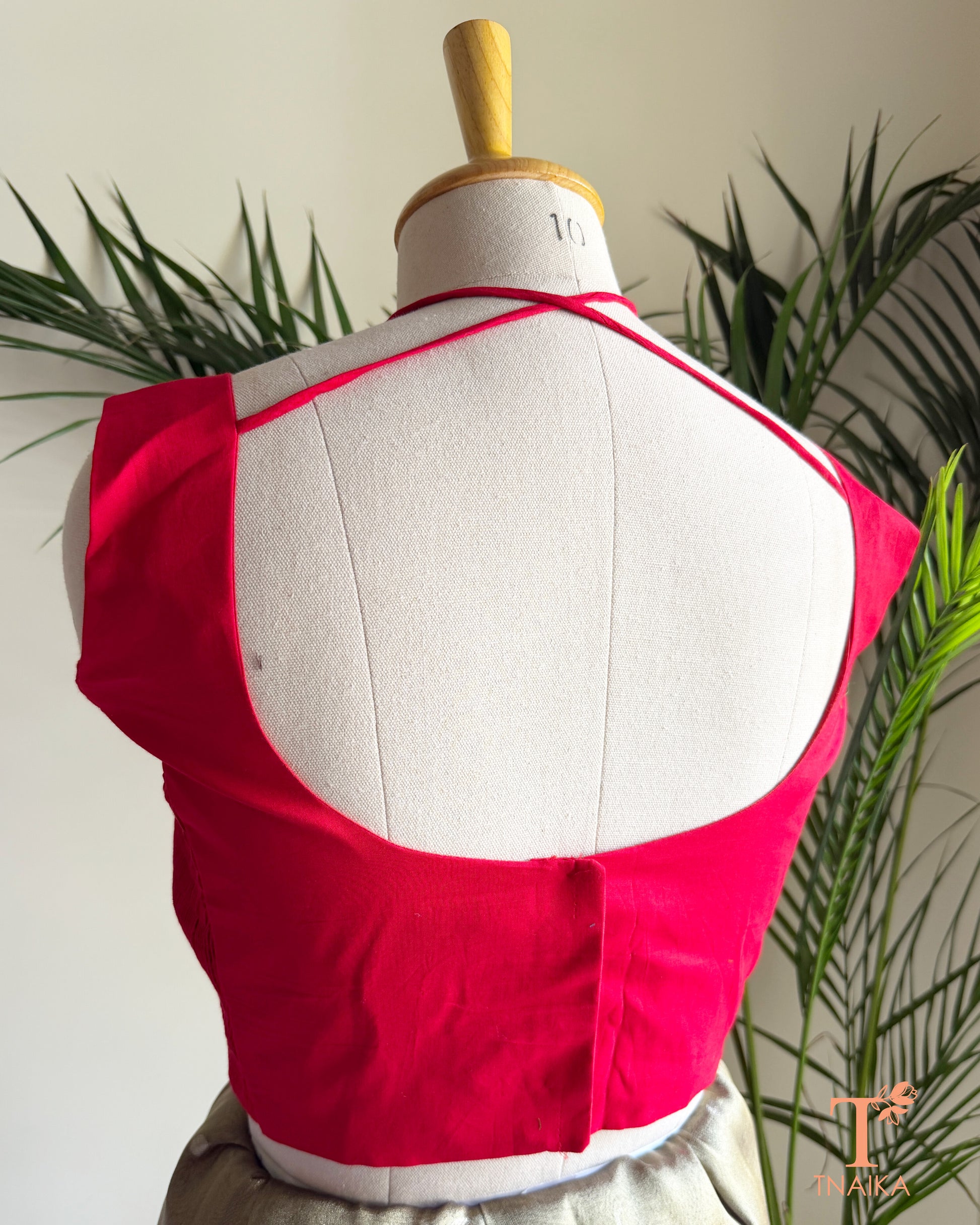 Designer cotton silk blouse with a stylish deep back neck and adjustable tie-up closure for a graceful saree look.
