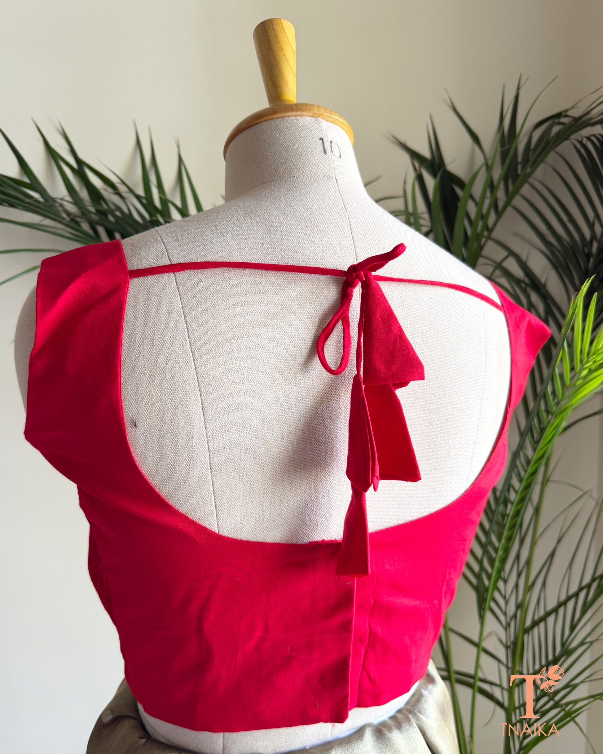 Back view of premium cotton silk blouse featuring a deep round back neckline, tie-up tassel detail, and elegant tailored finish.