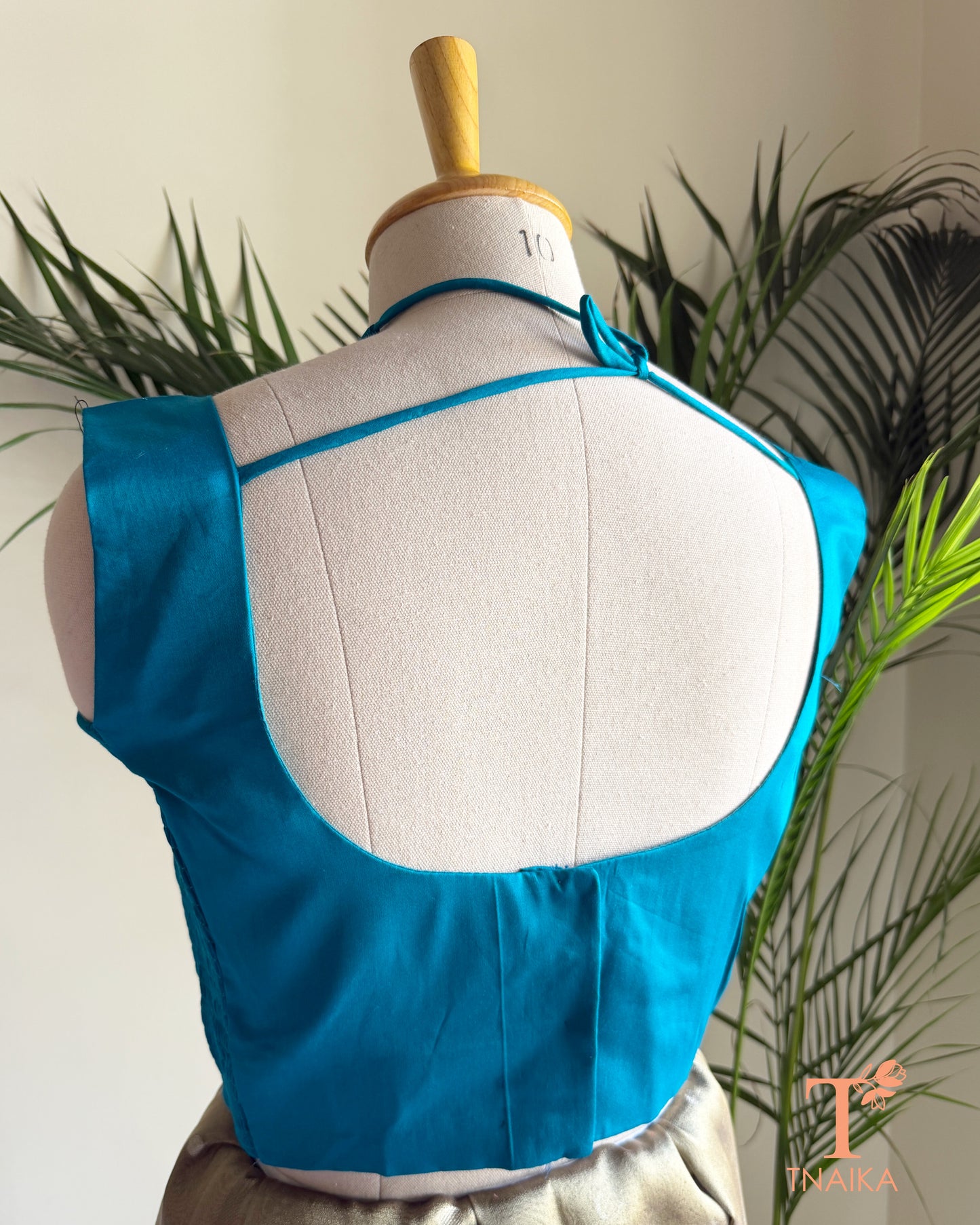 Designer cotton silk saree blouse showcasing a deep back neck with tie-up closure and premium finish.